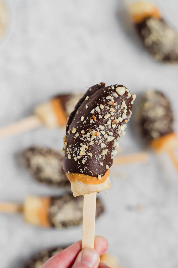 Frozen bananas get dipped in creamy peanut butter, and then rich chocolate and topped with roasted salted peanuts for a creamy, sweet treat. 